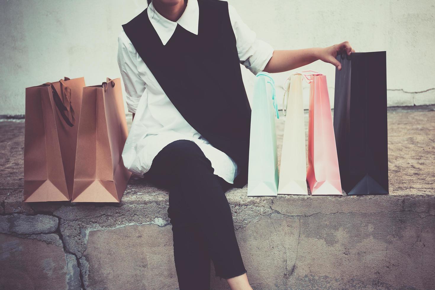 Woman hand holding shopping bags after shopping in the mall and walking to car park photo