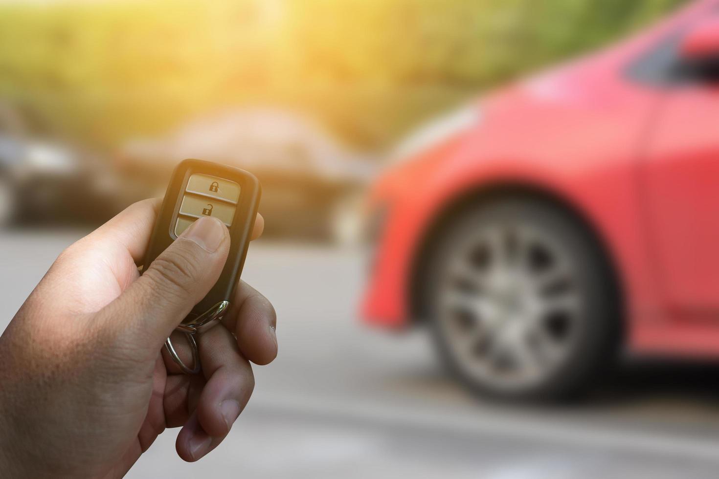 mano humana empujar una llave de coche de control remoto foto