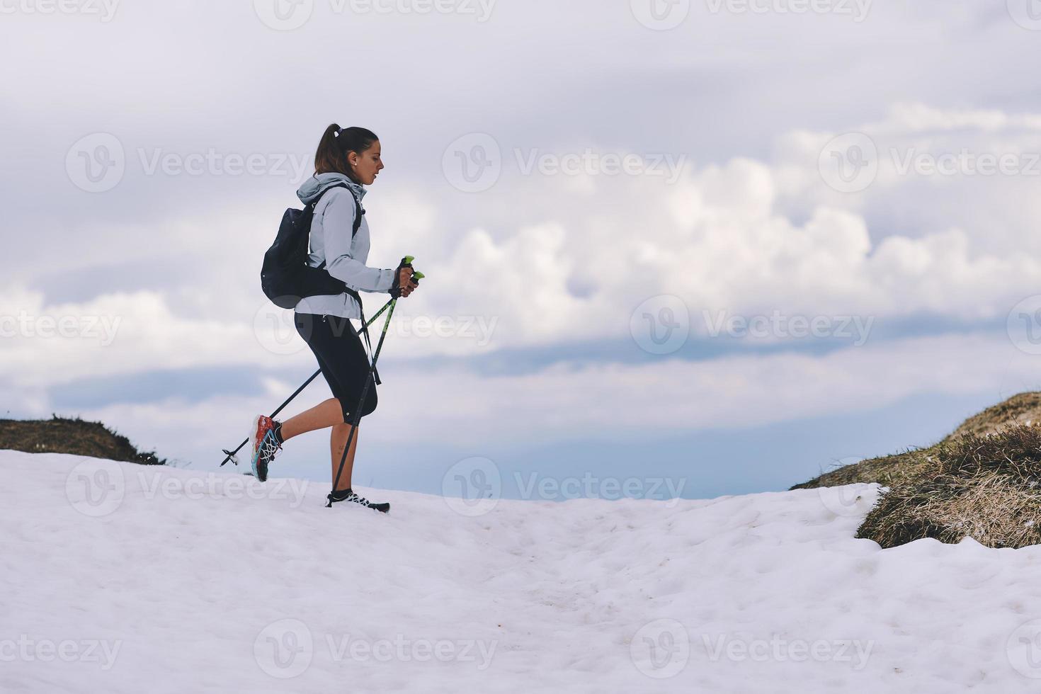 Chica apasionada de los deportes al aire libre durante la caminata sobre la nieve. foto