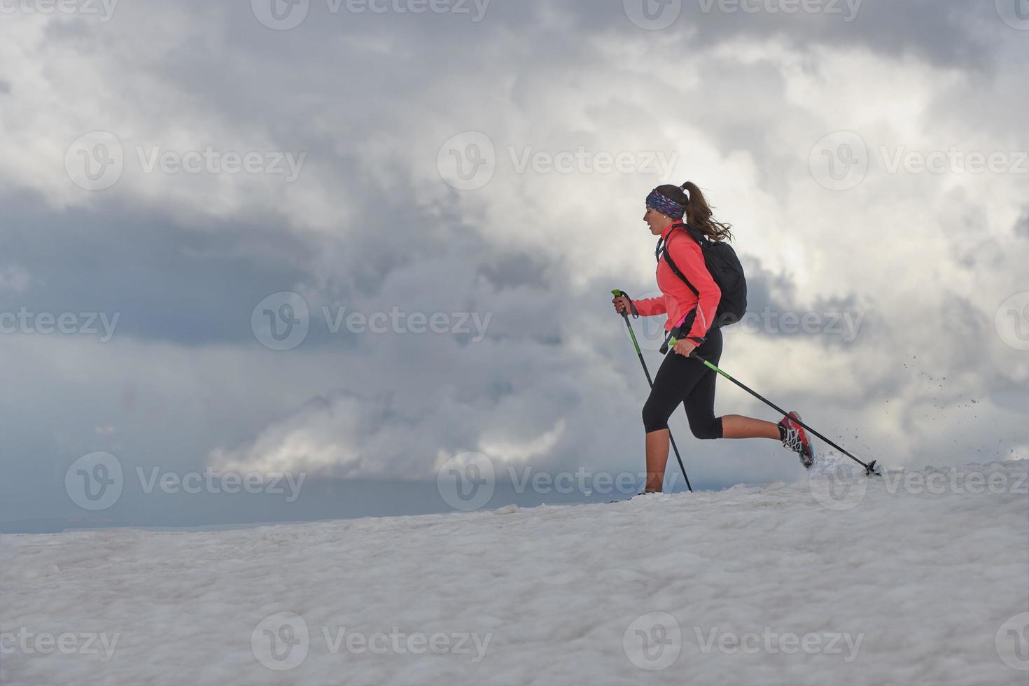 chica skyrunning practica en la nieve en las montañas foto