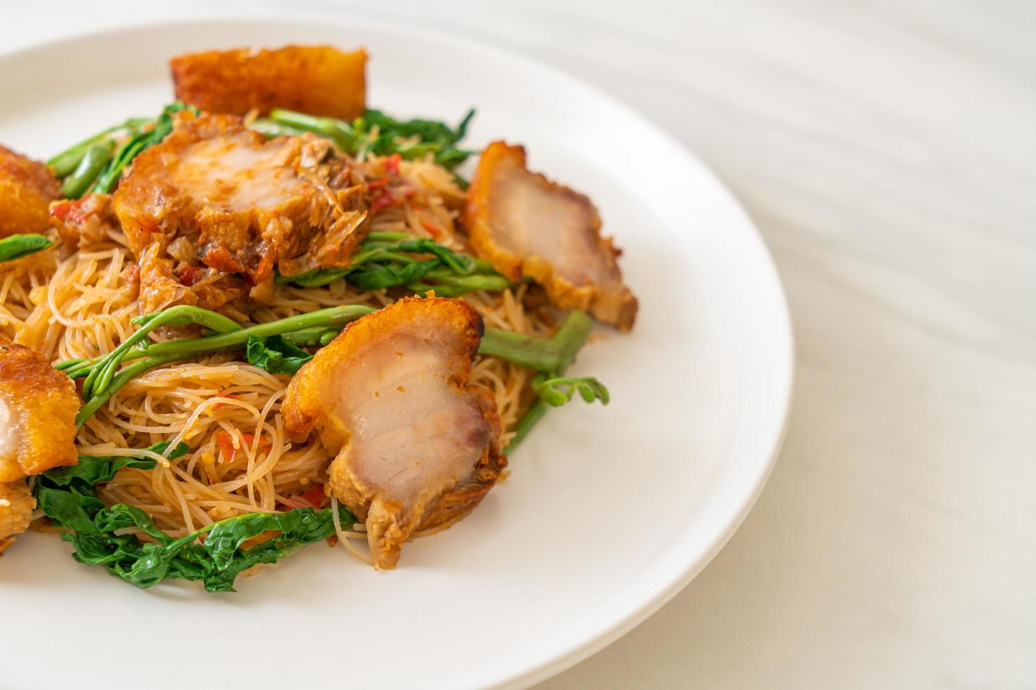 fideos de arroz salteados y mimosa de agua con panceta de cerdo crujiente foto