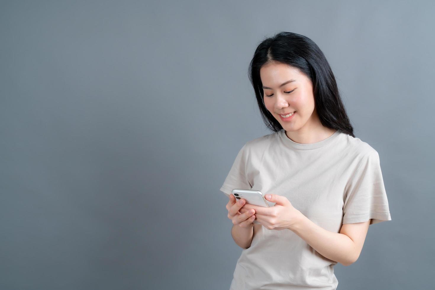 Mujer asiática que usa aplicaciones de teléfonos móviles disfrutando de la comunicación a distancia en línea en la red social o de compras foto