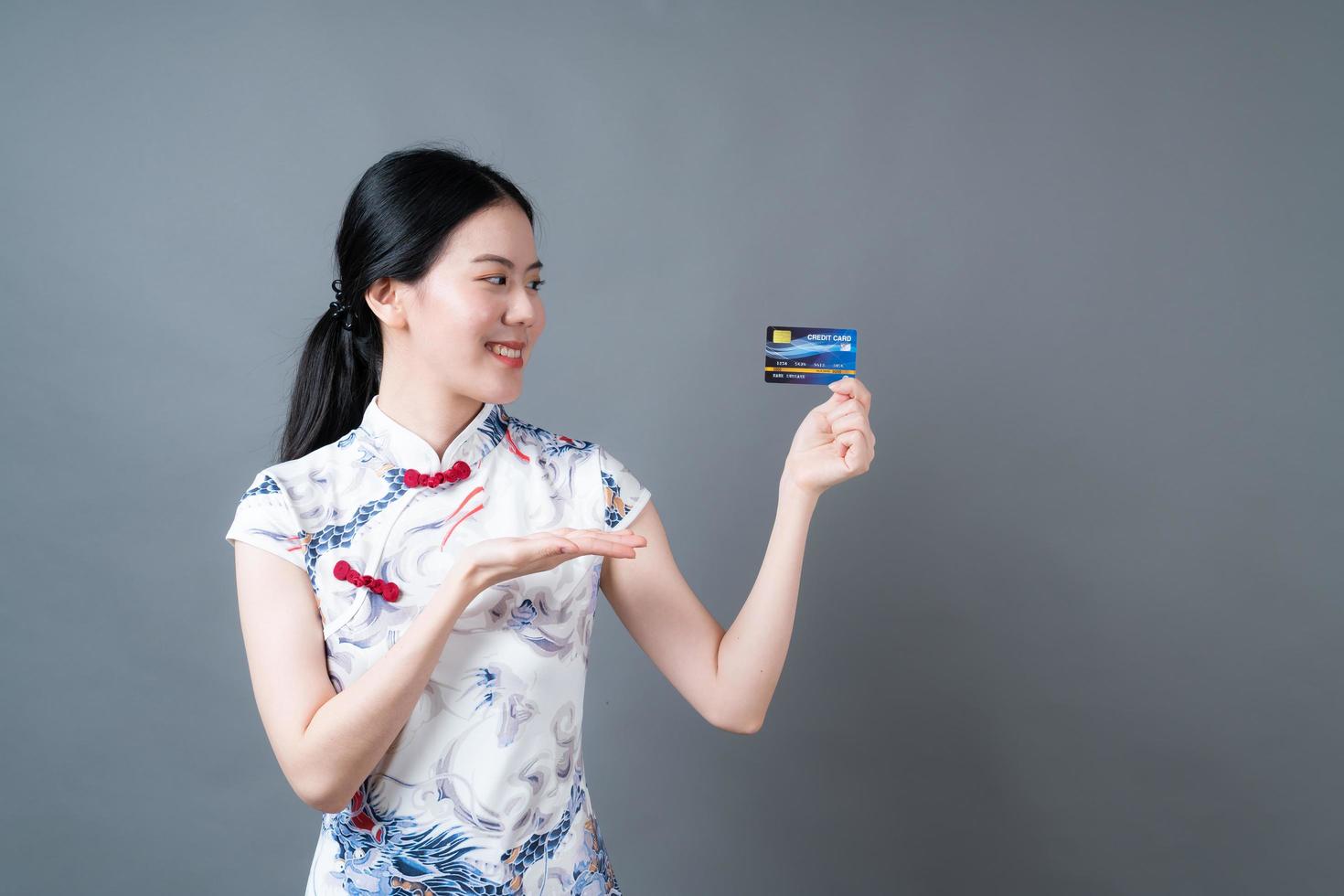 Asian woman wear Chinese traditional dress with hand holding credit card photo