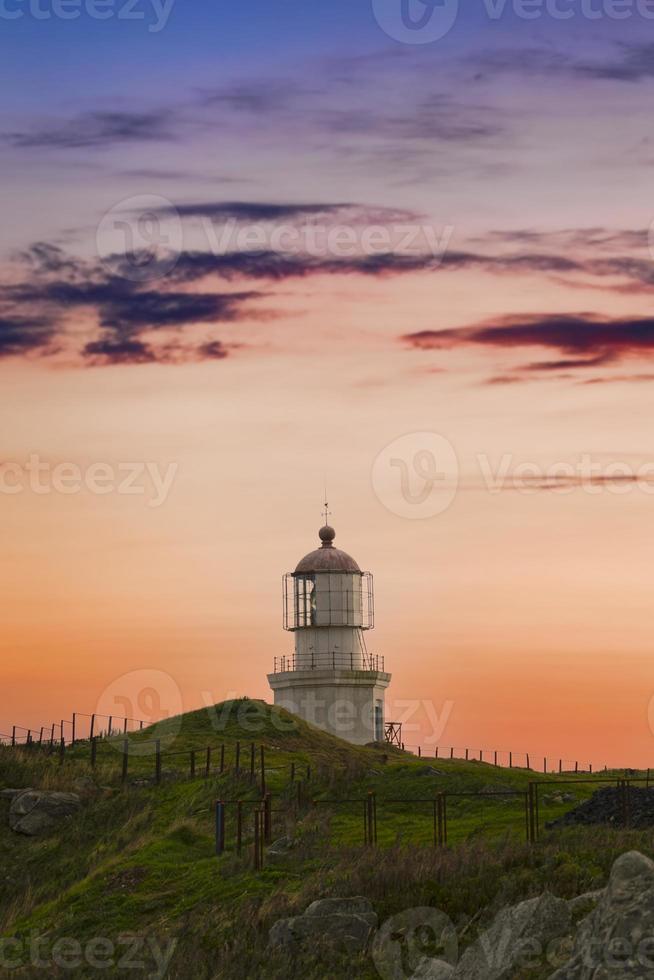 paisaje con un viejo faro en el fondo de la puesta de sol foto