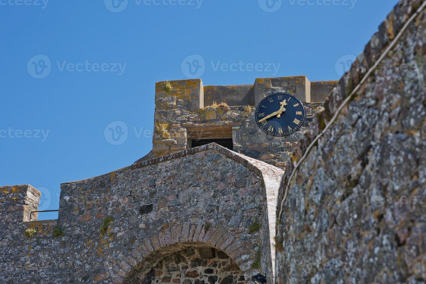 Un reloj en las paredes del castillo Cornet en St Peter Port, Guernsey, Reino Unido foto