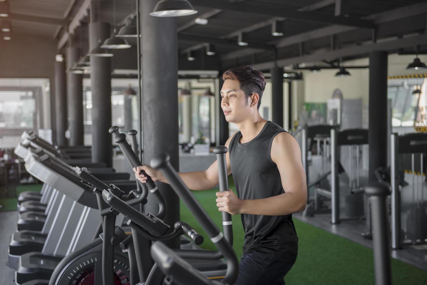 Handsome man running on a treadmill in a gym photo