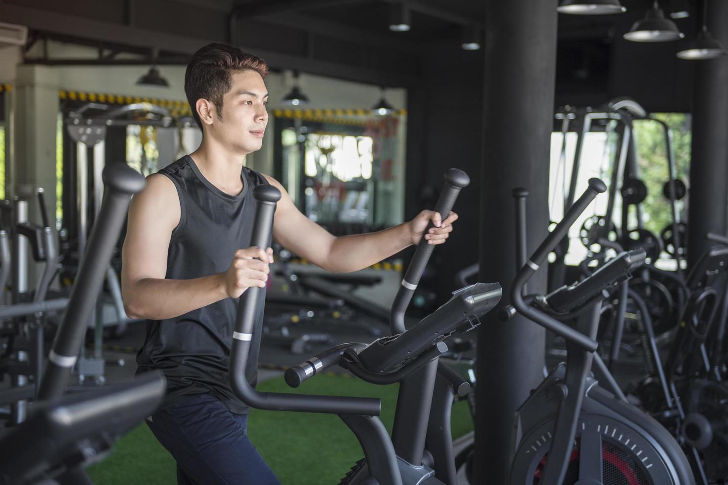 Guapo corriendo en una cinta en un gimnasio foto