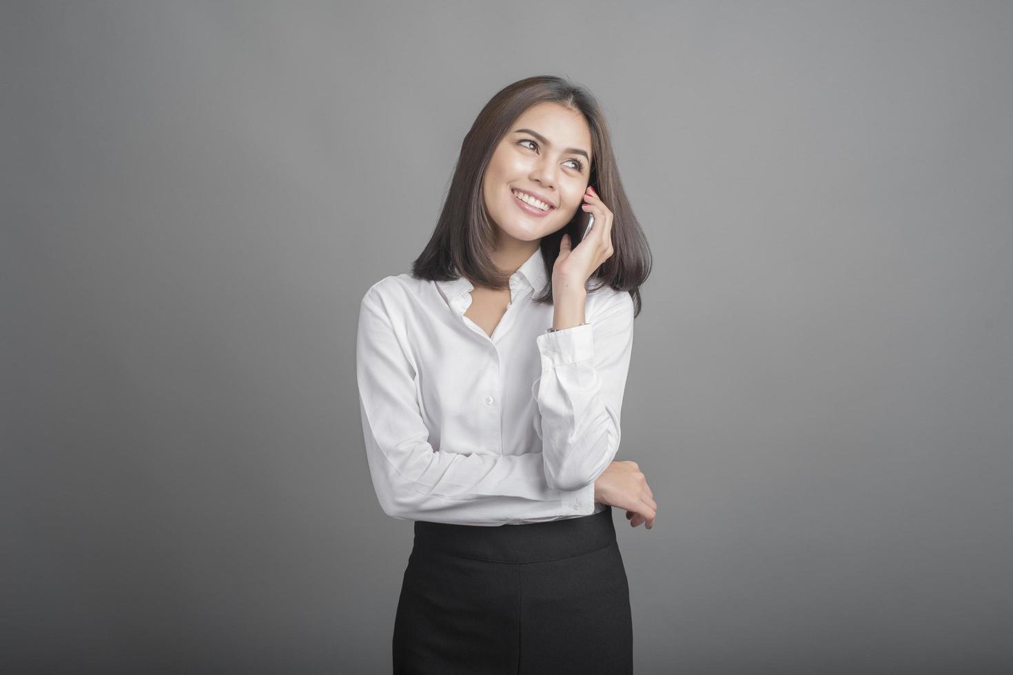 mujer de negocios, en, camisa blanca, en, fondo gris foto