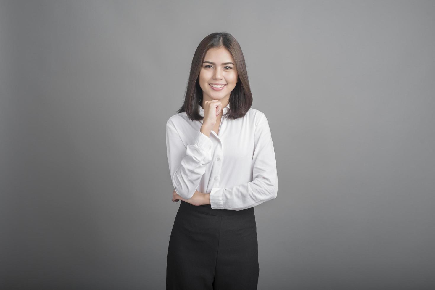 mujer de negocios, en, camisa blanca, en, fondo gris foto