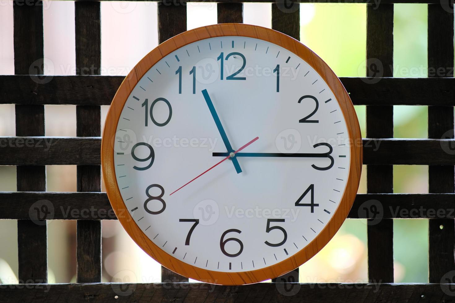 Wall clock on wood background and time concept photo