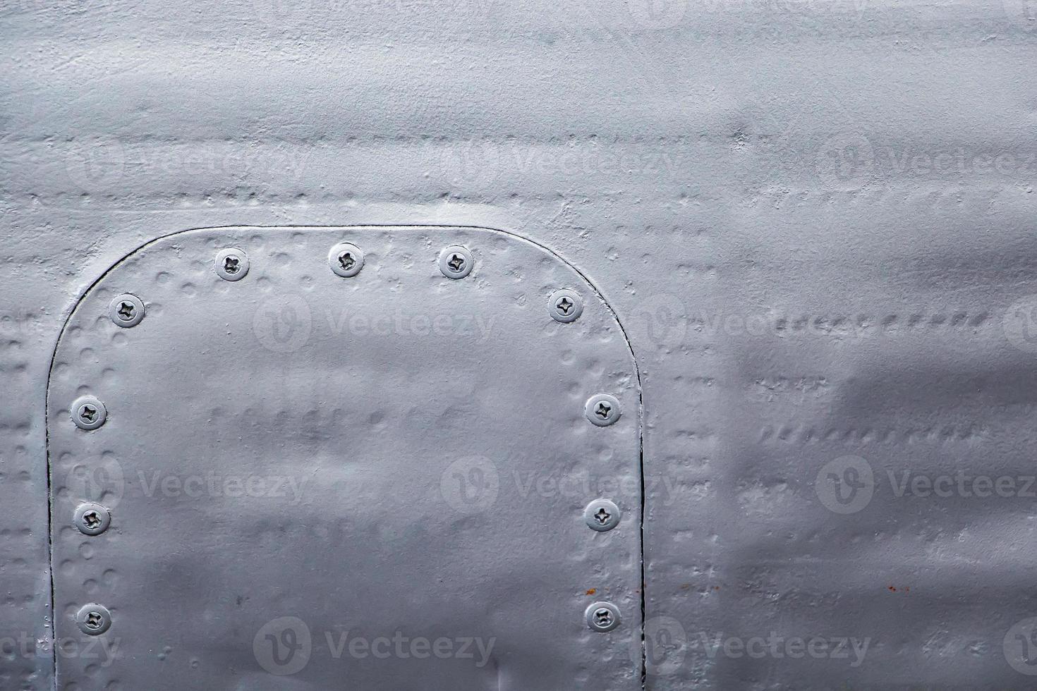 Aircraft skin close up. Rivets on gray metal. photo