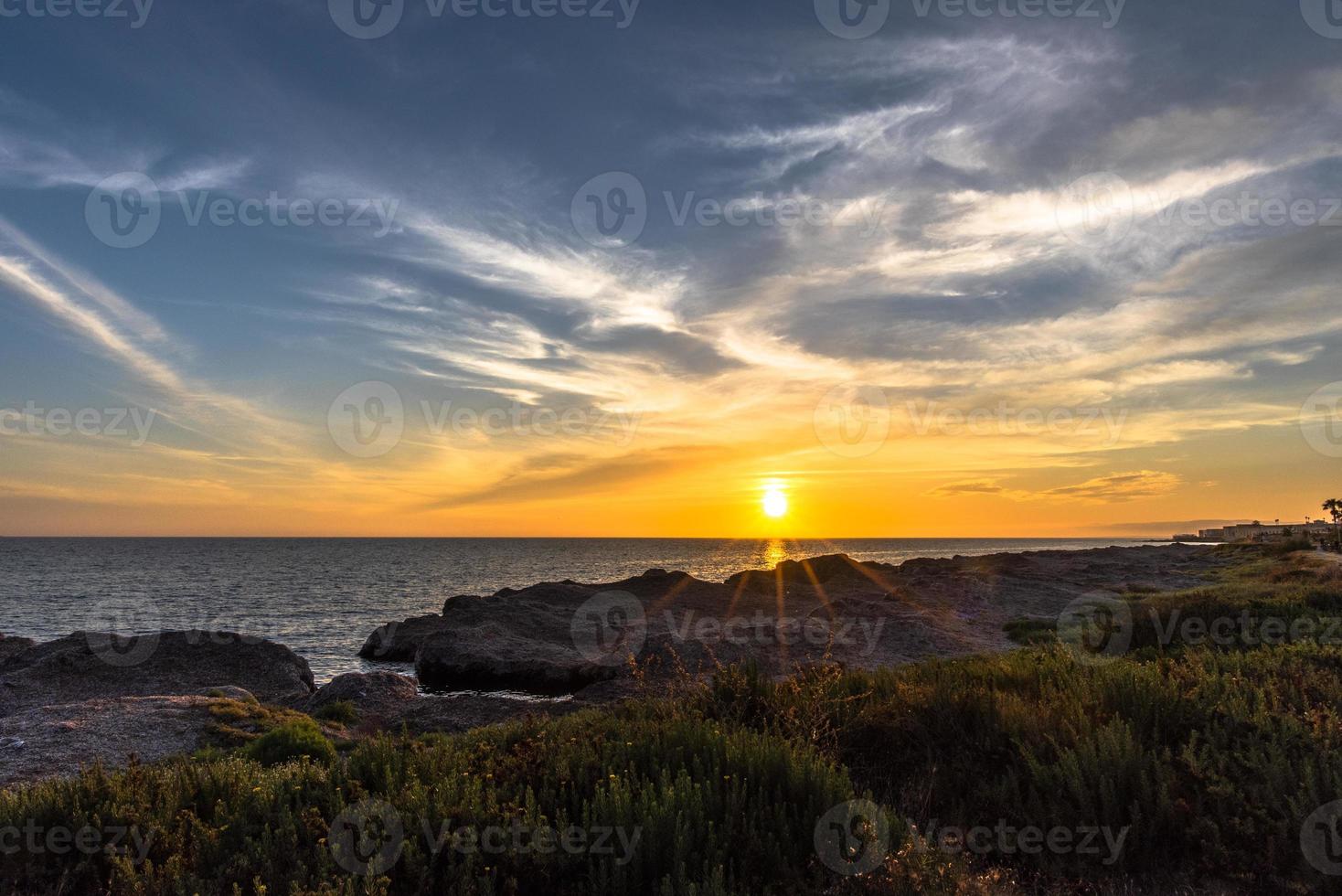 Sunset between the rocks and the sea photo