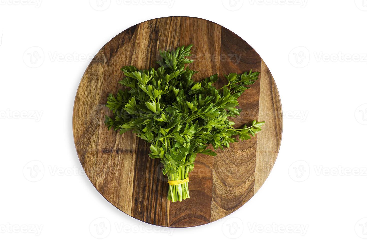 Green parsley leaf on a wooden cutting board, isolate photo