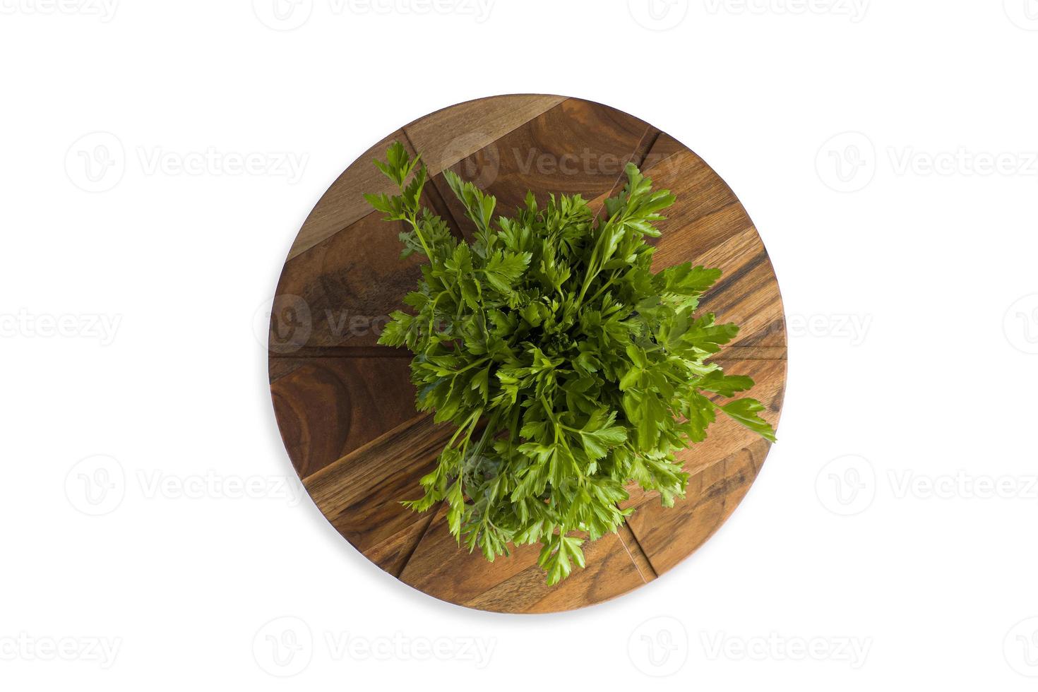 Hoja de perejil verde sobre una tabla de cortar de madera, aislar foto