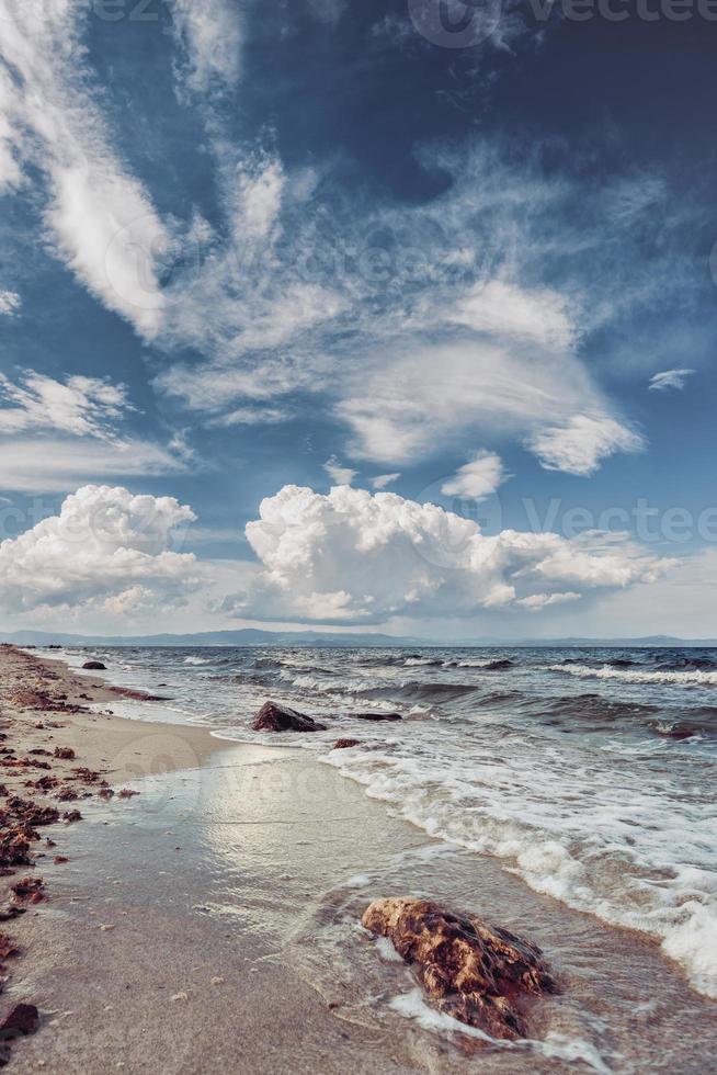 Landscape of sand and rocky shore. Beautiful cloudy seascape at sunset and blurred motion water. photo