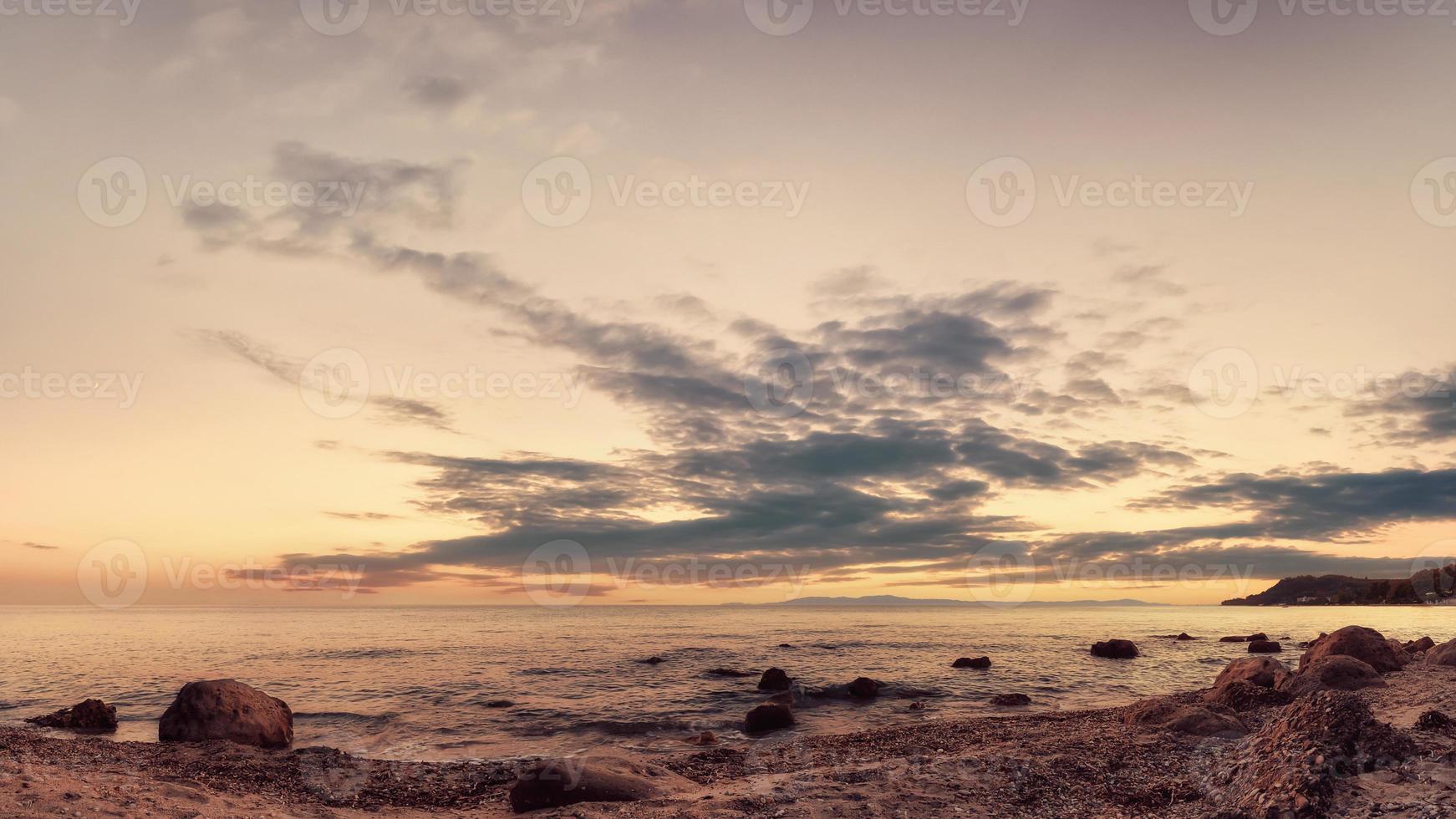 paisaje de arena y costa rocosa. Hermoso paisaje marino nublado al atardecer, Kassandra, Grecia. foto