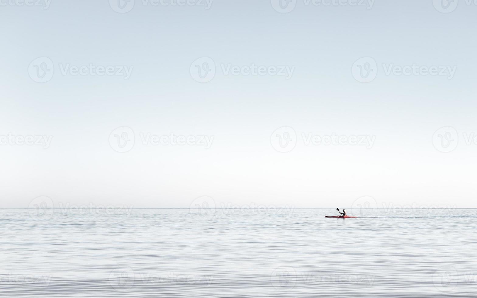 hombre en kayak en las aguas muy tranquilas del mar. Hombre en kayak a primera hora de la tarde en el mar Egeo, Grecia. foto