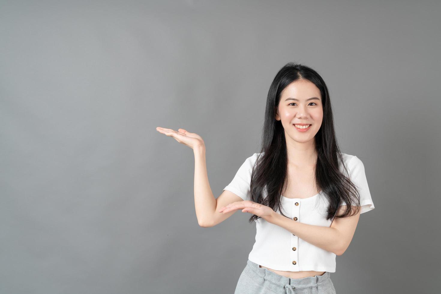 Asian woman with smiling face and hand presenting on side photo