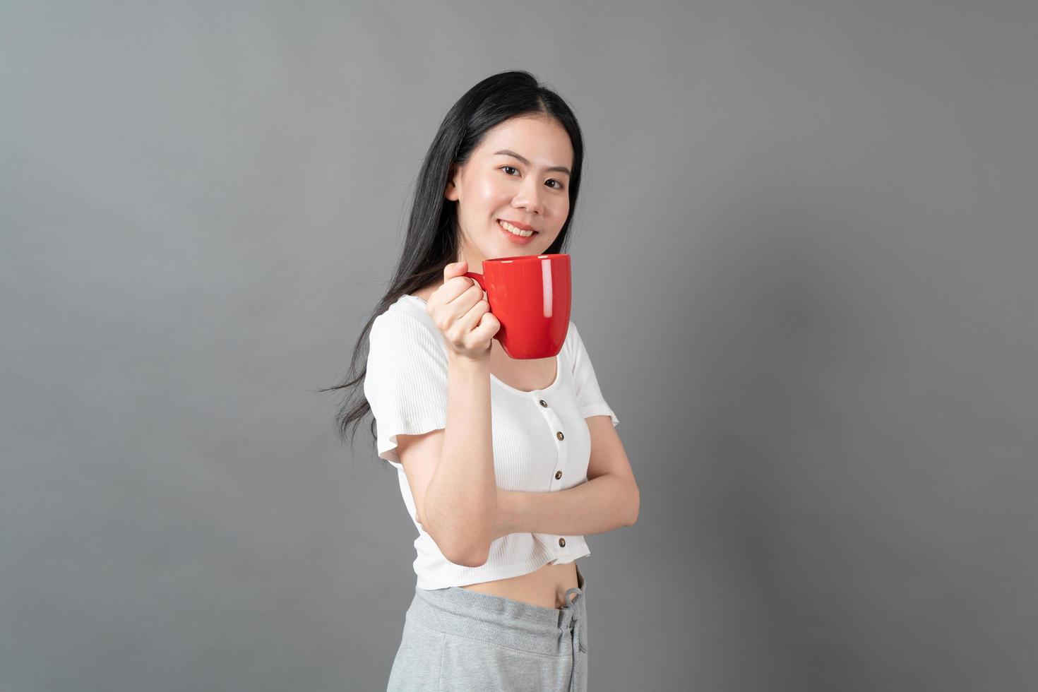 Young Asian woman with happy face and hand holding coffee cup photo