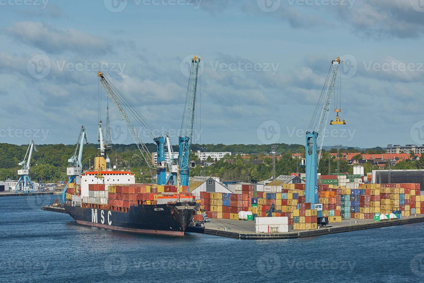 Grúa portuaria carga un contenedor en Fredericia, Dinamarca foto