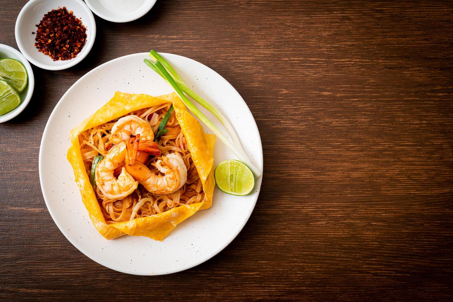 Thai stir fried noodles with shrimps and egg wrap photo