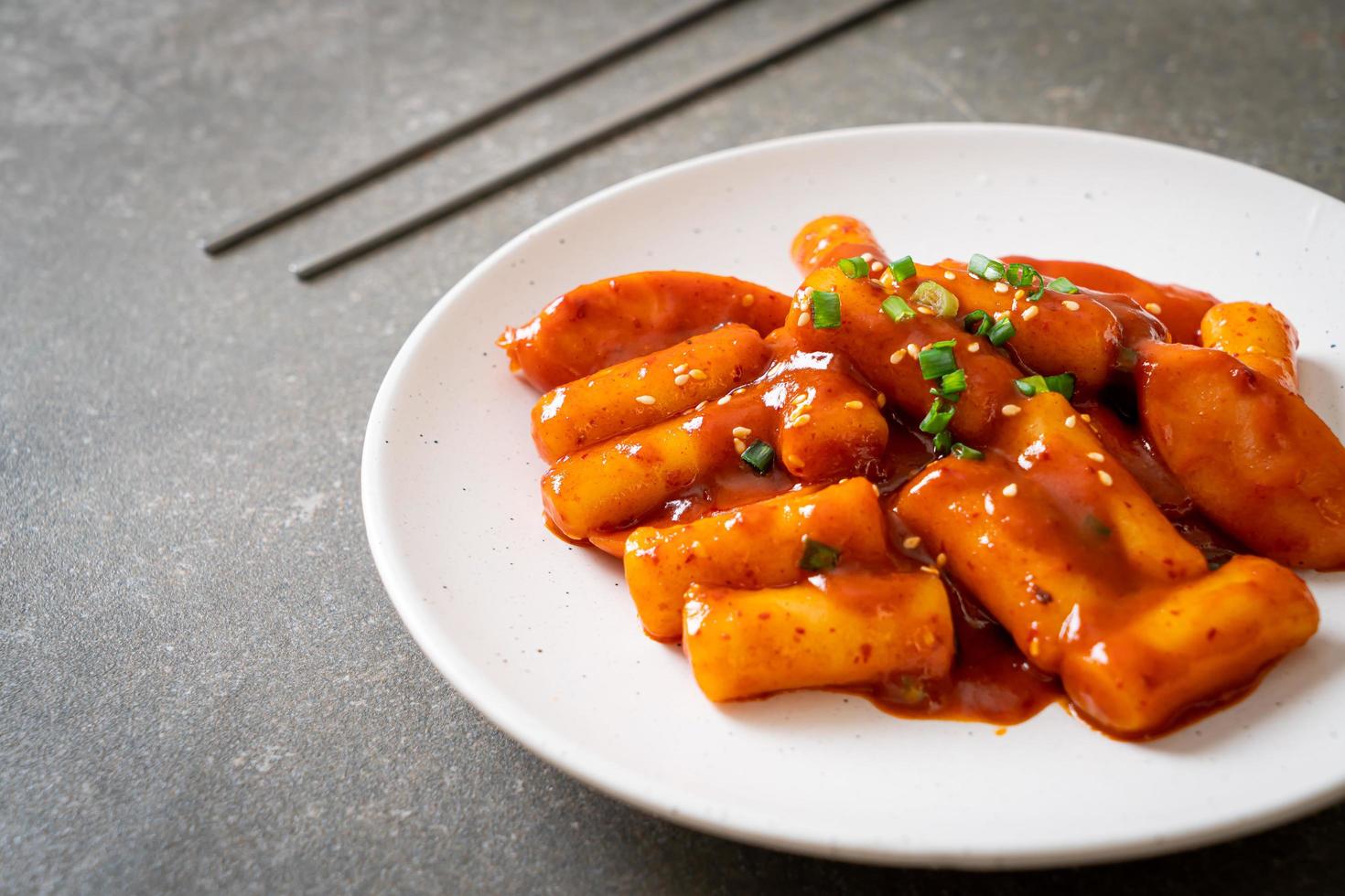 Korean rice cake stick with sausage in spicy sauce - Tteokbokki photo