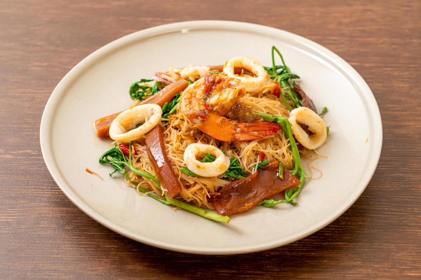 Fideos de arroz salteados y mimosa de agua con mezcla de mariscos foto