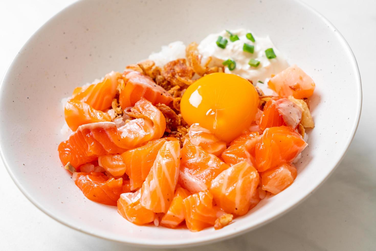 arroz japonés con salmón fresco crudo y huevo foto