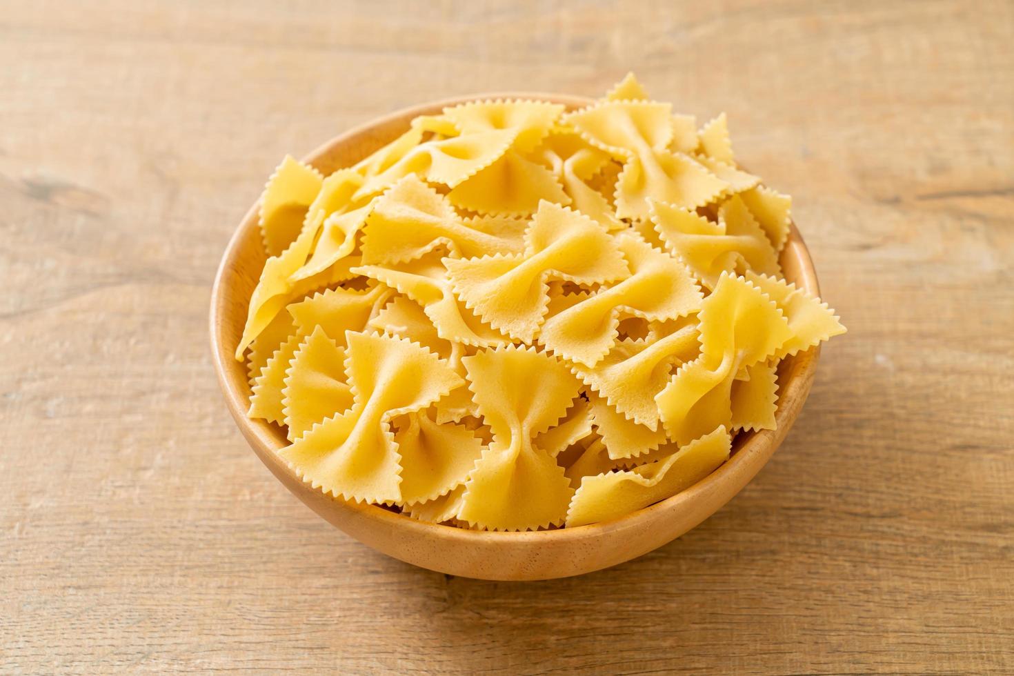 Dry uncooked farfalle pasta in bowl photo