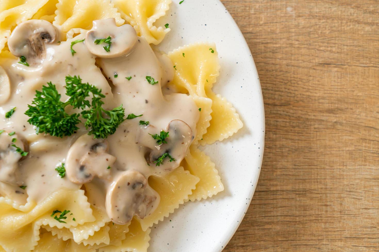 Farfalle pasta with mushroom white cream sauce - Italian food style photo