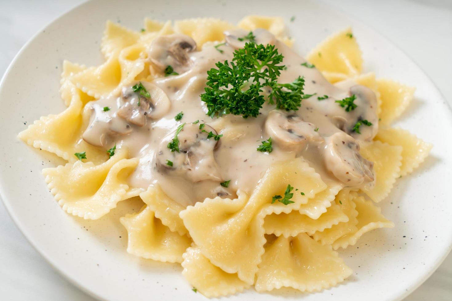 Pasta farfalle con salsa de crema blanca de champiñones - estilo de comida italiana foto