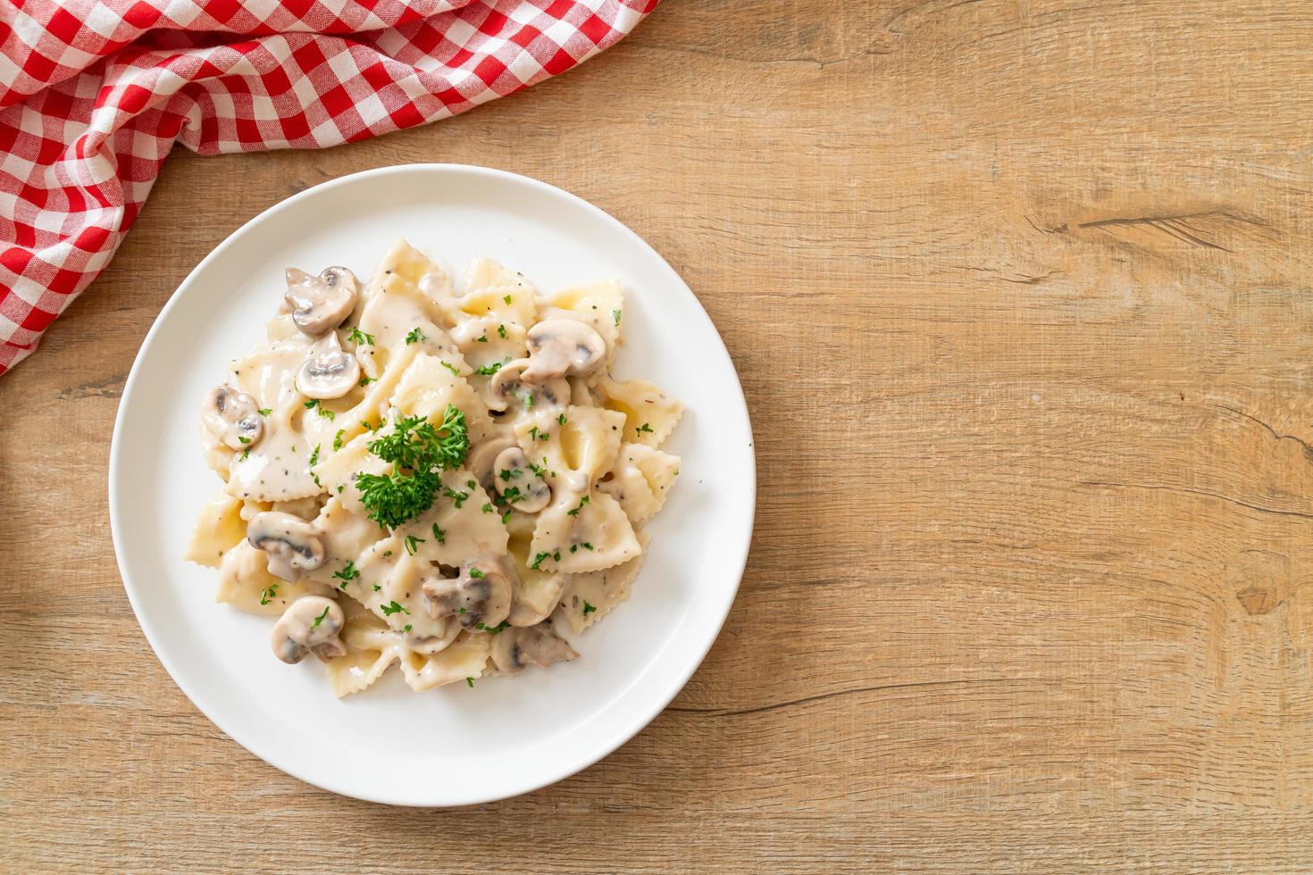 Pasta farfalle con salsa de crema blanca de champiñones - estilo de comida italiana foto