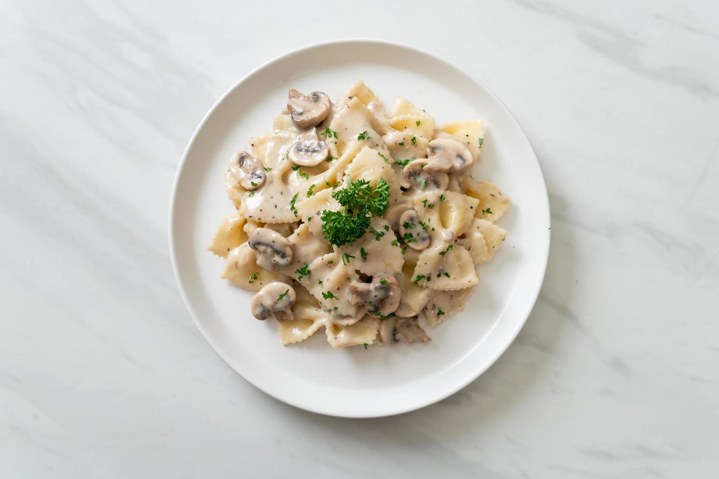 Pasta farfalle con salsa de crema blanca de champiñones - estilo de comida italiana foto