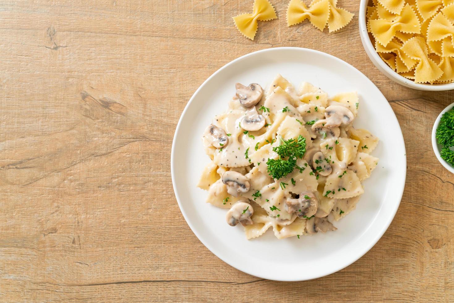 Pasta farfalle con salsa de crema blanca de champiñones - estilo de comida italiana foto