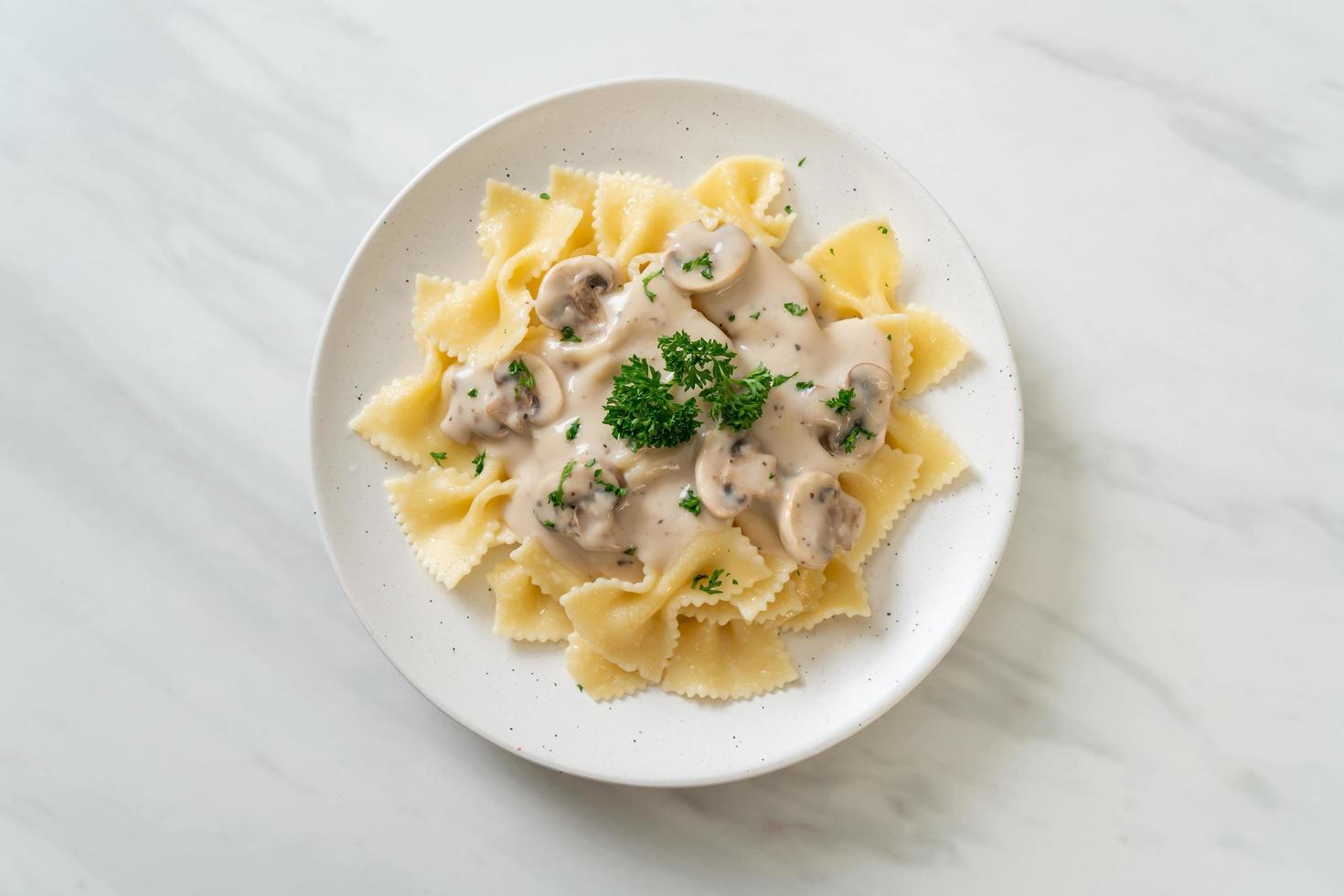 Pasta farfalle con salsa de crema blanca de champiñones - estilo de comida italiana foto