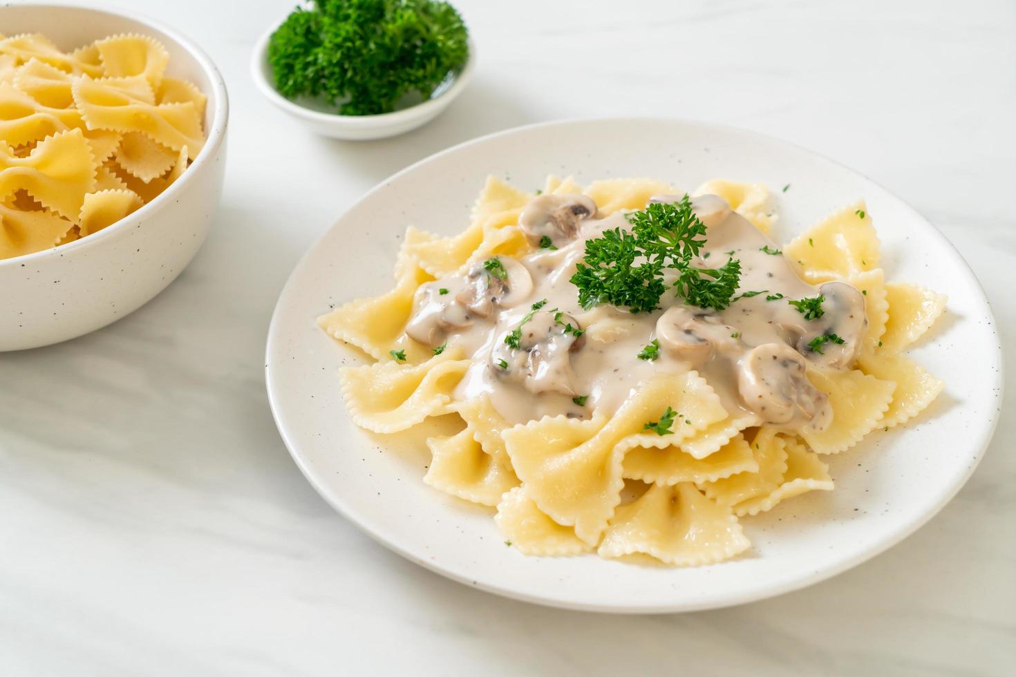 Pasta farfalle con salsa de crema blanca de champiñones - estilo de comida italiana foto