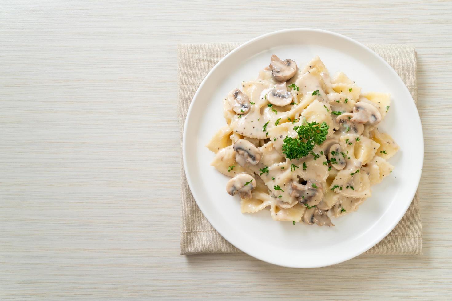 Pasta farfalle con salsa de crema blanca de champiñones - estilo de comida italiana foto