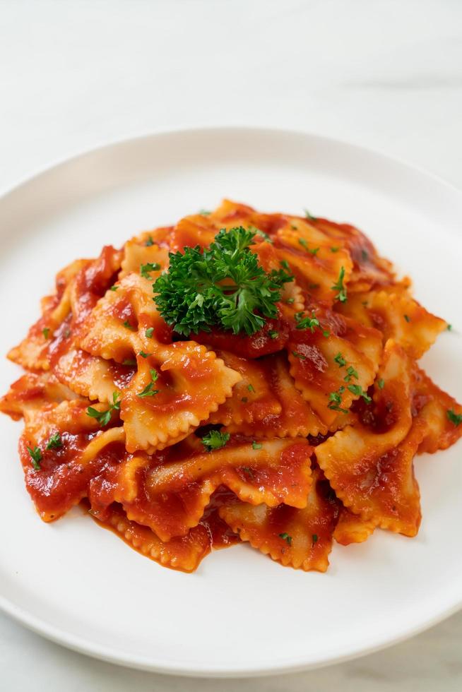 Pasta farfalle en salsa de tomate con perejil - estilo de comida italiana foto