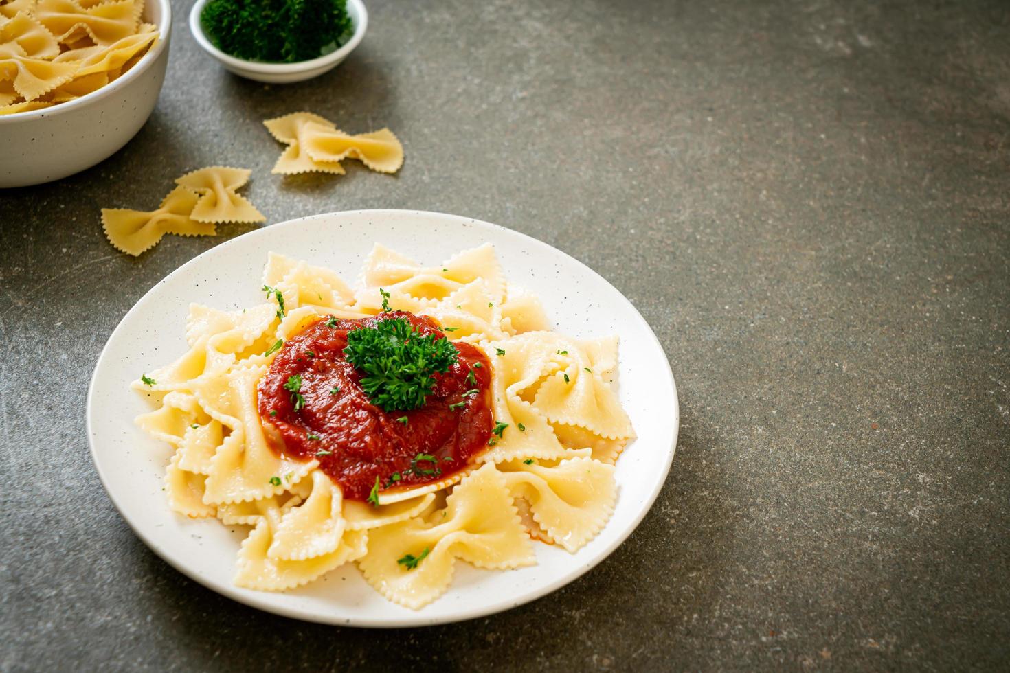 Pasta farfalle en salsa de tomate con perejil - estilo de comida italiana foto