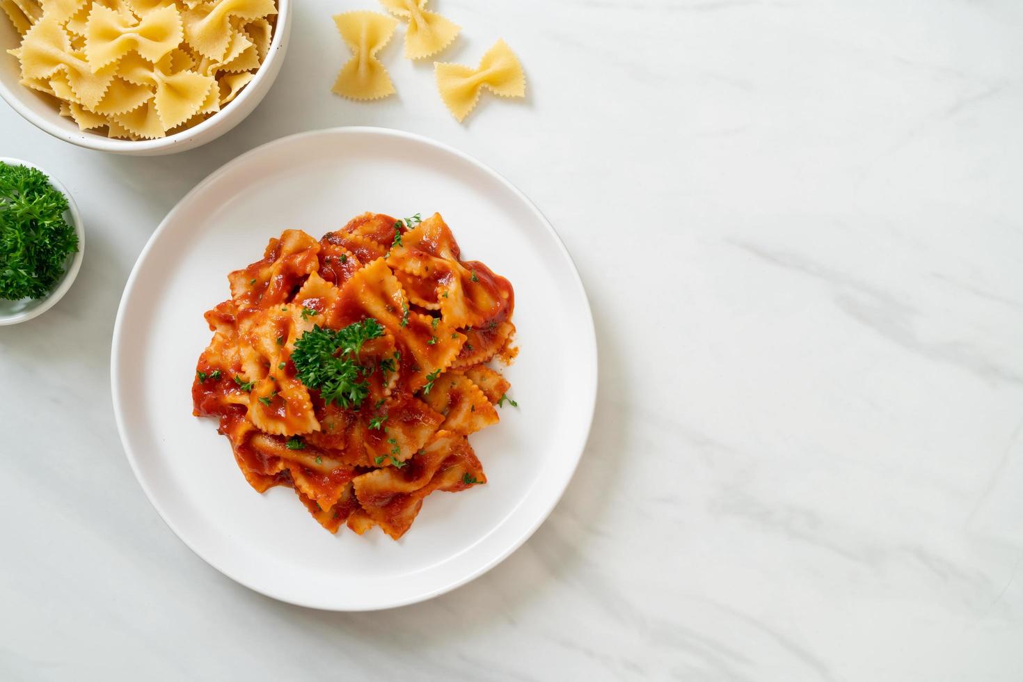 Pasta farfalle en salsa de tomate con perejil - estilo de comida italiana foto