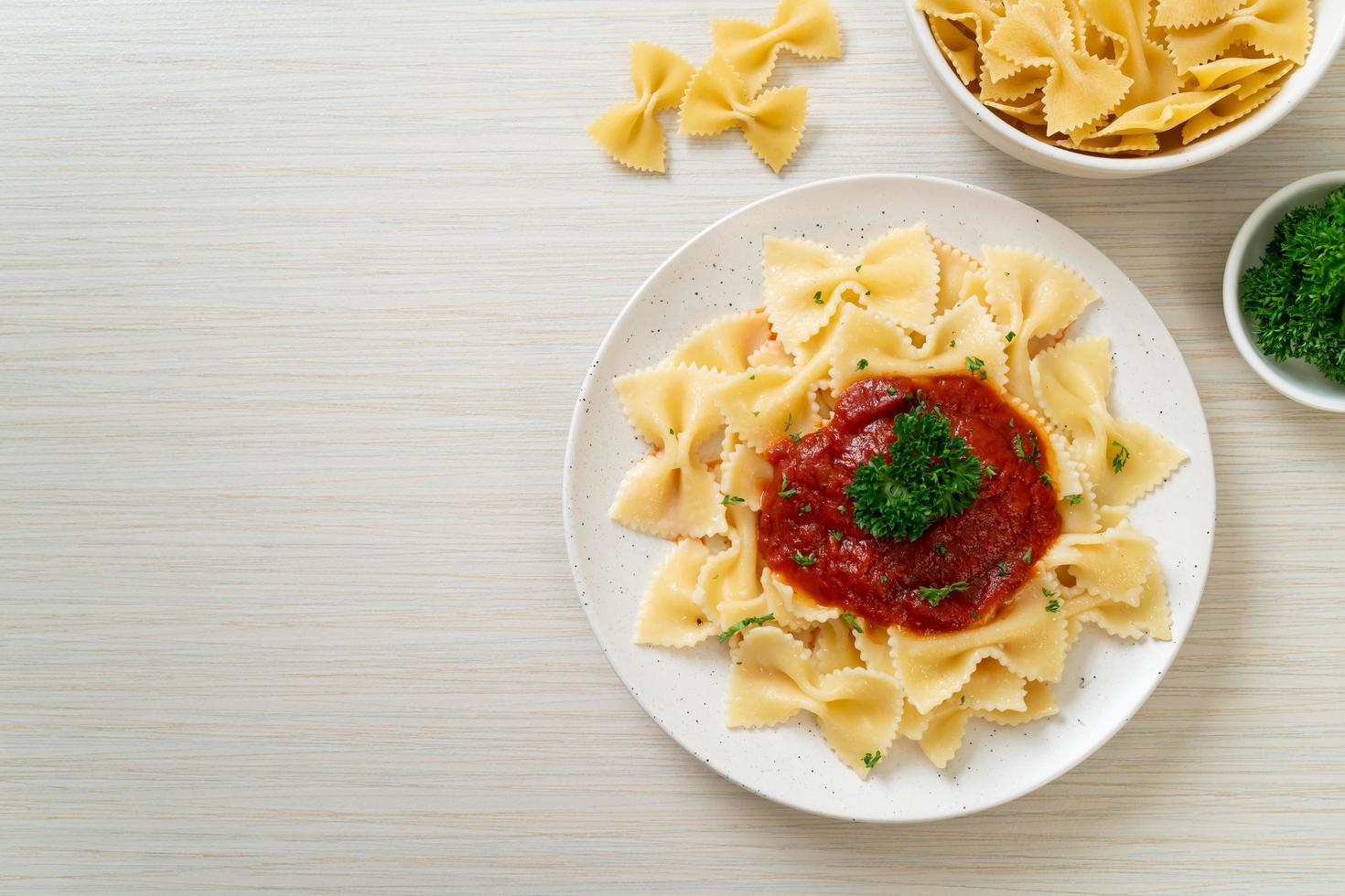 Pasta farfalle en salsa de tomate con perejil - estilo de comida italiana foto