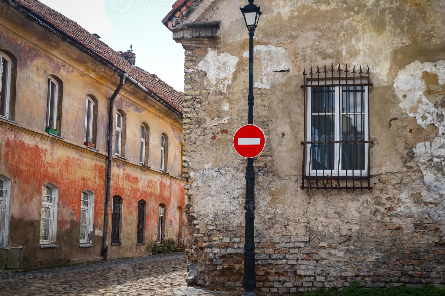 Señal de stop roja en la luz de la calle cerca del edificio de la ciudad vieja con ventana foto