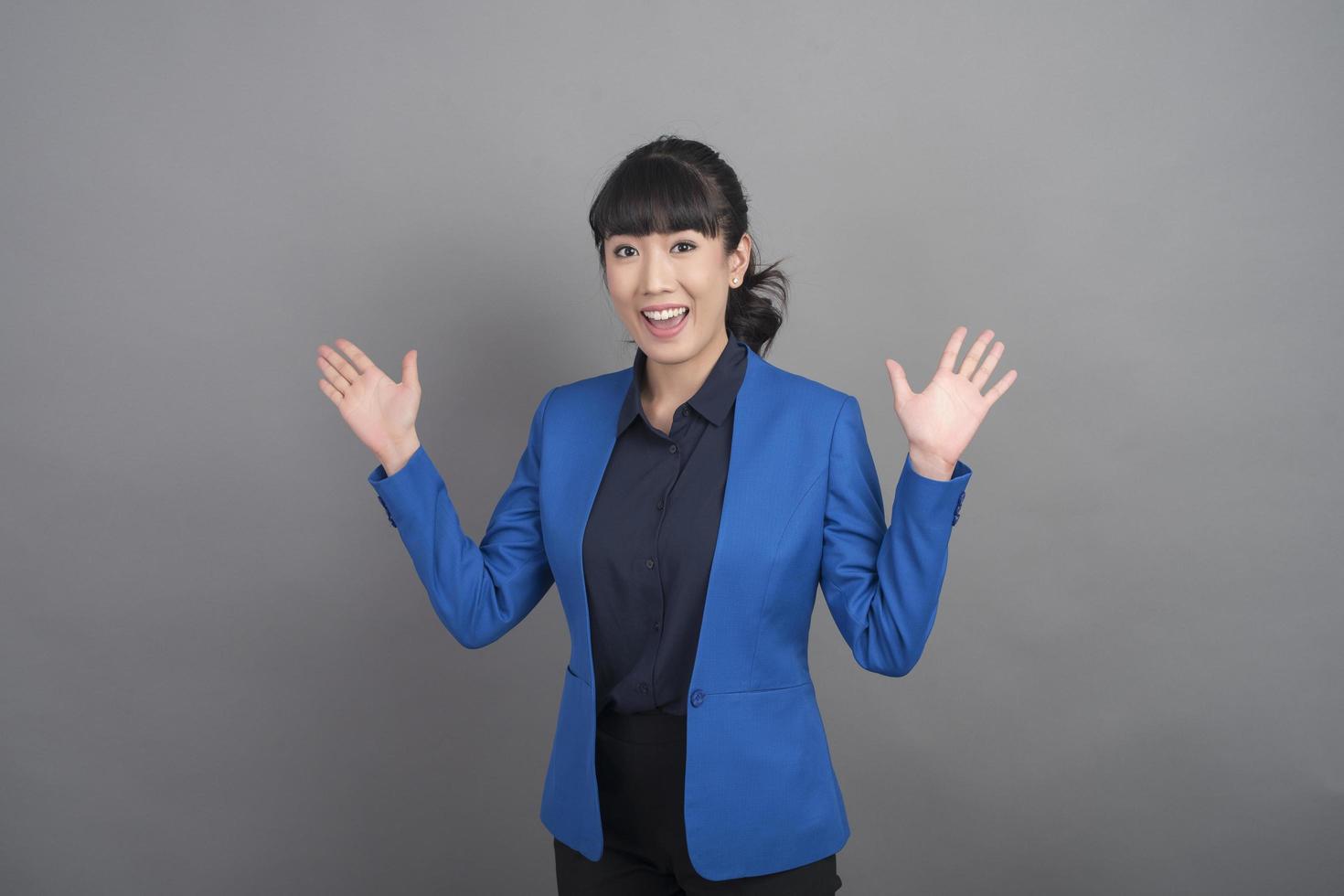 Smiling business woman in blue blazer on grey background photo