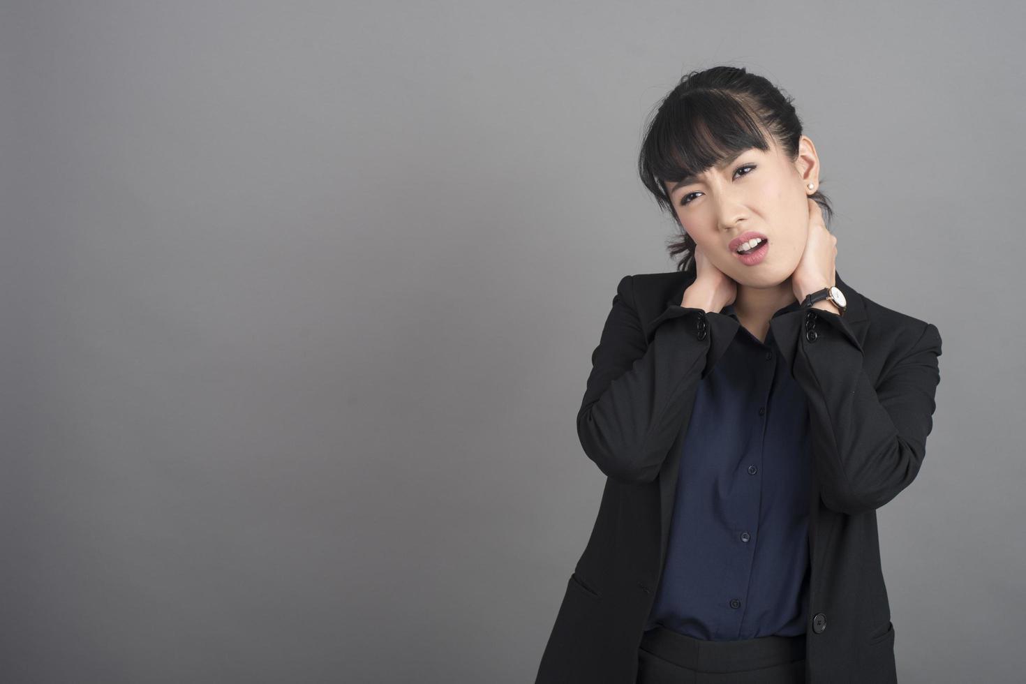 Smiling business woman in blazer on grey background photo