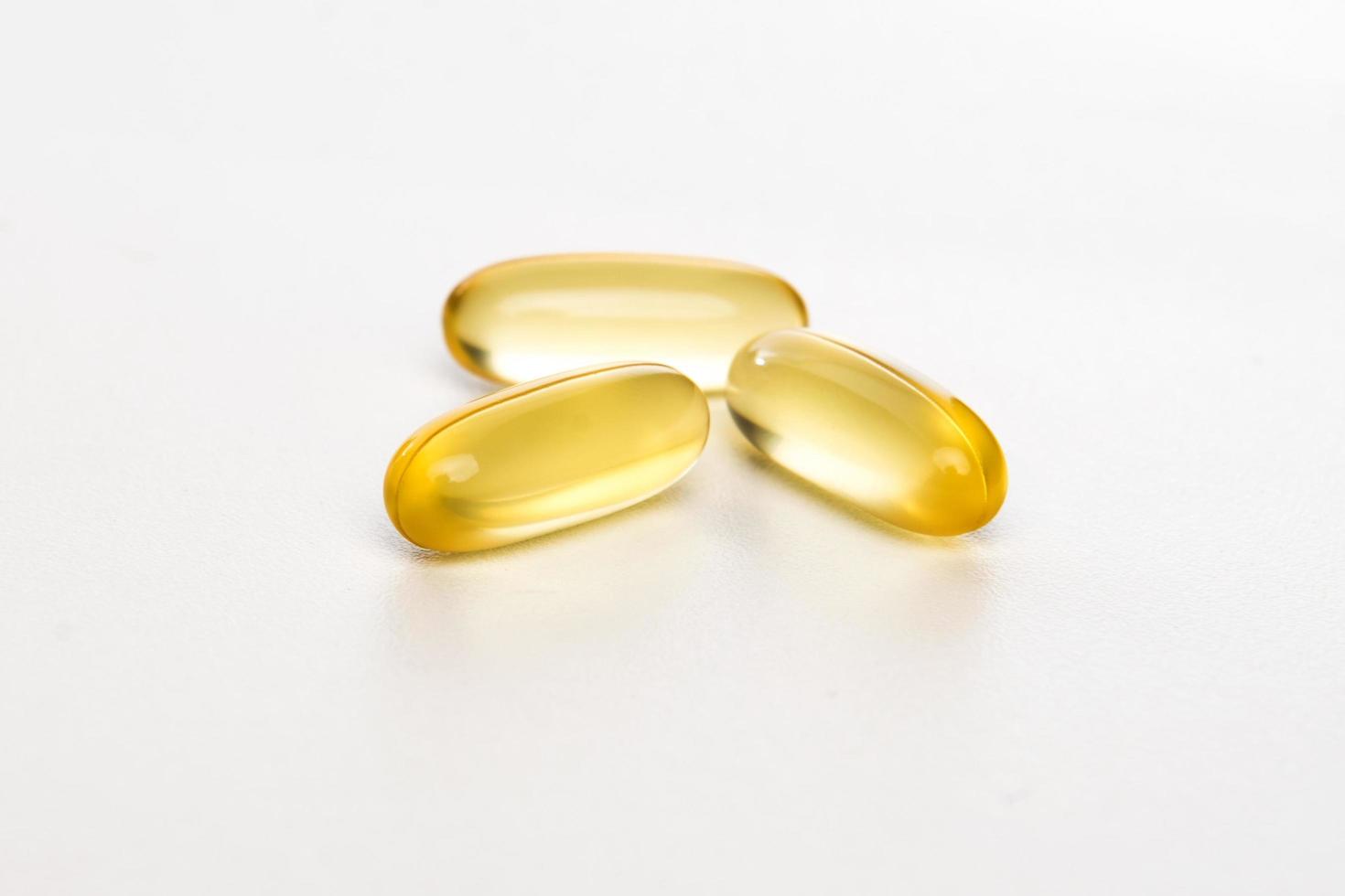 Yellow pills on white background photo