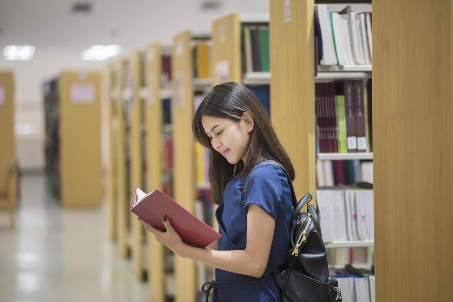 hermosa mujer asiática estudiante universitario en la biblioteca foto