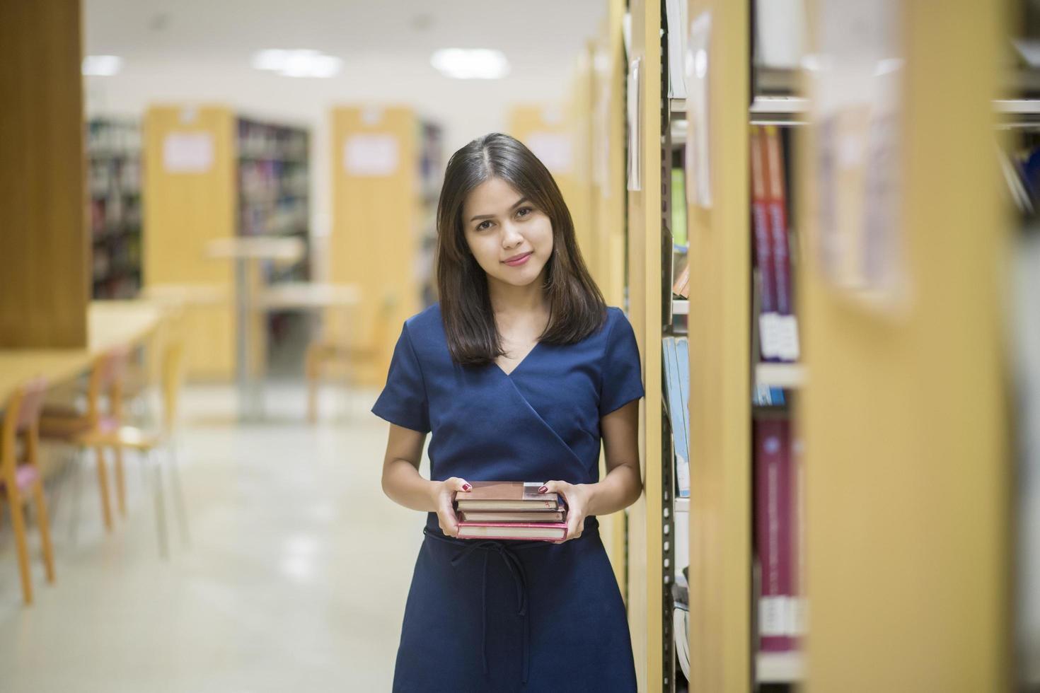 hermosa mujer asiática estudiante universitario en la biblioteca foto