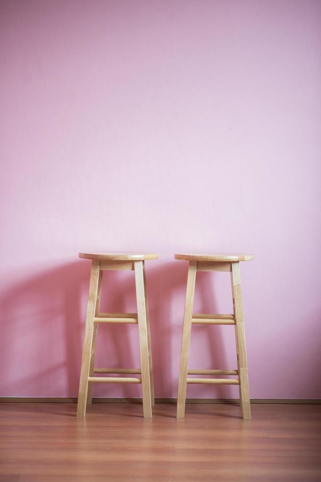 Bar stools on pink wall photo