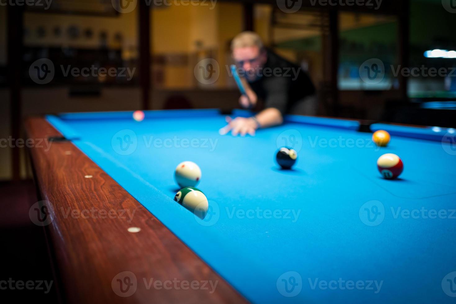 un hombre jugando al billar foto