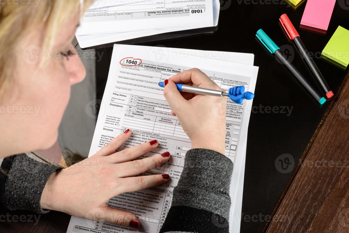 Woman fills the tax form, working with tax documents. Form 1040 Individual Income Tax return form. United States Tax forms. American blank tax forms. Tax time. photo